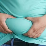 A man holding his stomach with his hands